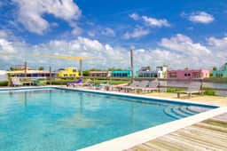 Sunny waterfront villa with outdoor pool, balcony, & AC