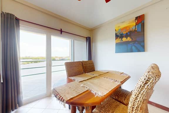 Sunny waterfront villa with outdoor pool, balcony, & AC