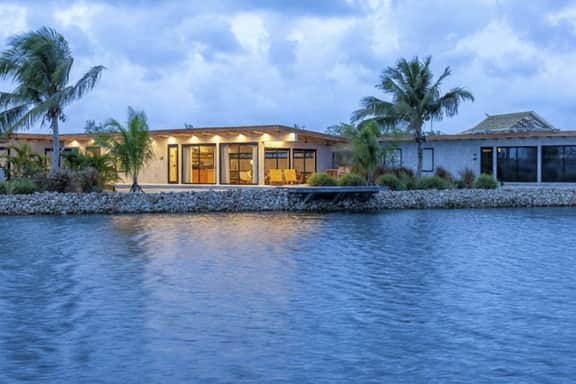 Stylish waterfront villa with pool, lush views & floor-to-ceiling windows