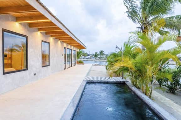 Stylish waterfront villa with pool, lush views & floor-to-ceiling windows