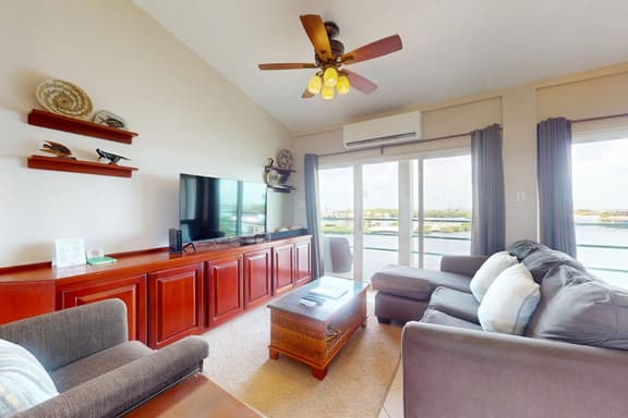 Sunny waterfront villa with outdoor pool, balcony, & AC