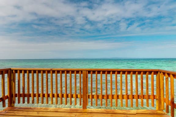 Overwater cabin with oceanfront deck, island kitchen & sea breeze views