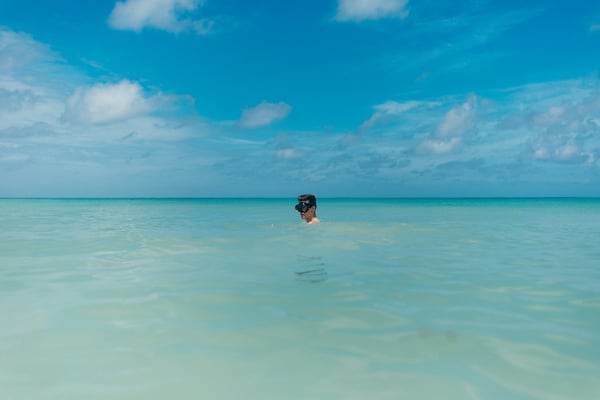 Person swimming in calm flat turquoise Caribbean water